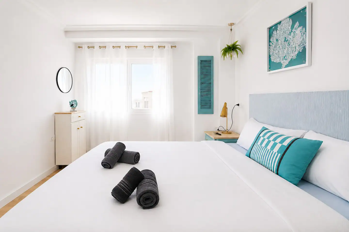 Dormitorio principal con cama doble y detalles en turquesa