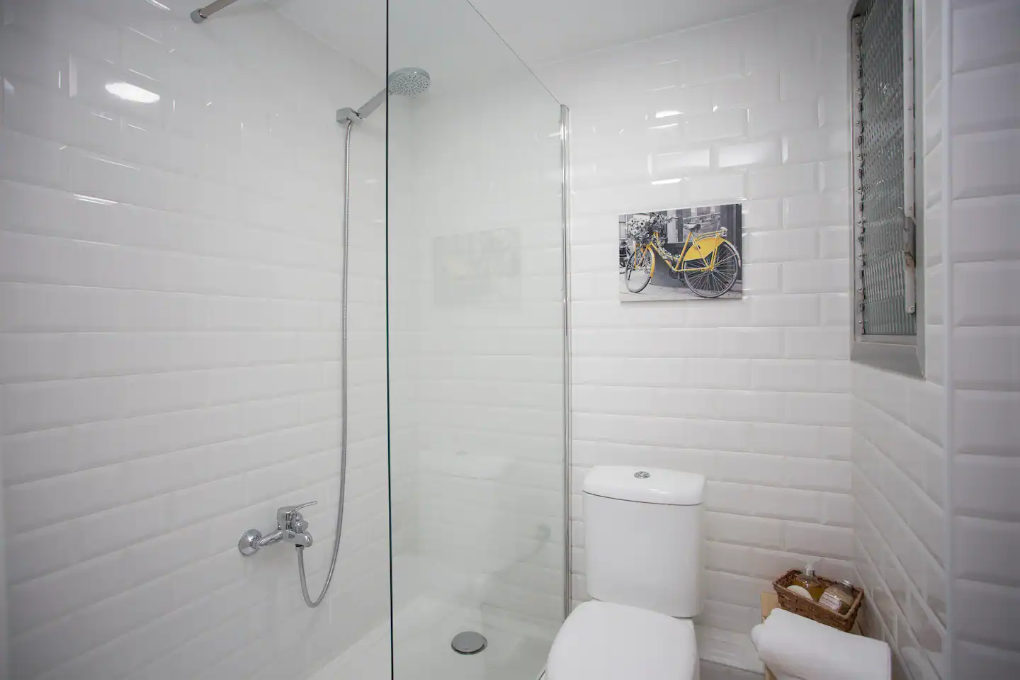 Baño con azulejo blanco y ducha