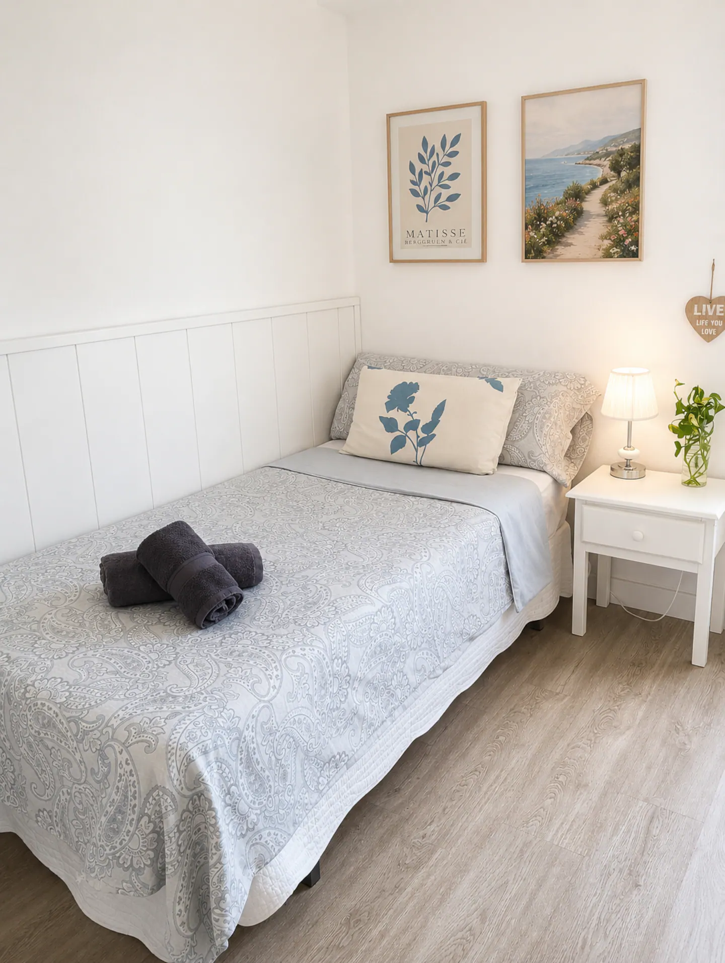 Cama individual con ropa de cama en gris y blanco