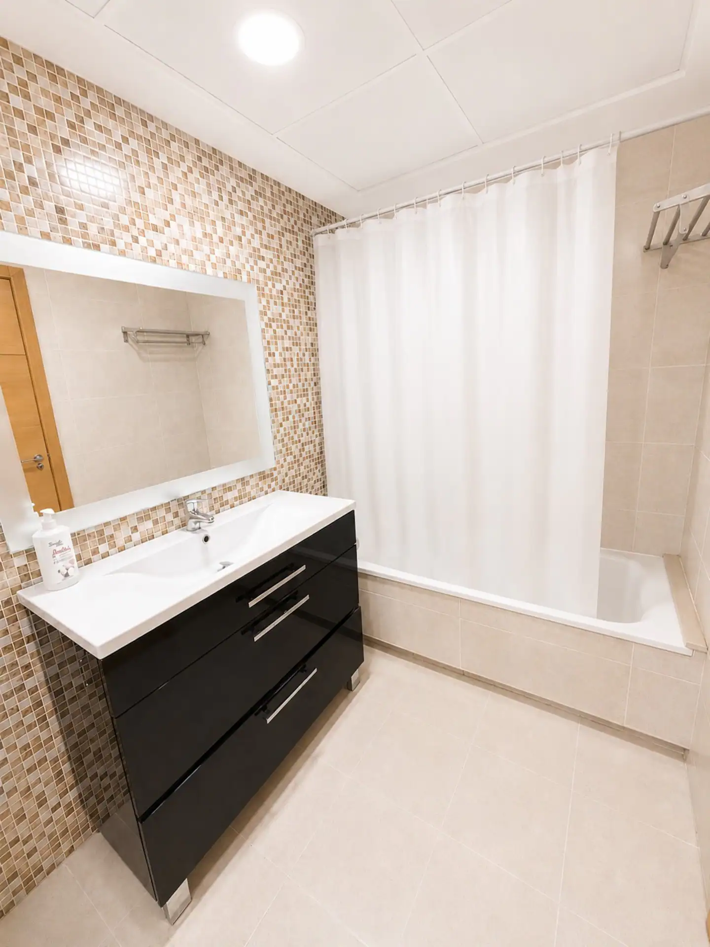 Segundo baño con bañera y mueble de lavabo oscuro